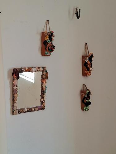 a mirror hanging on a wall with pictures on it at Serrambi Praia Suites in Porto De Galinhas