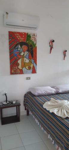 a bedroom with two beds and a painting on the wall at Serrambi Praia Suites in Porto De Galinhas