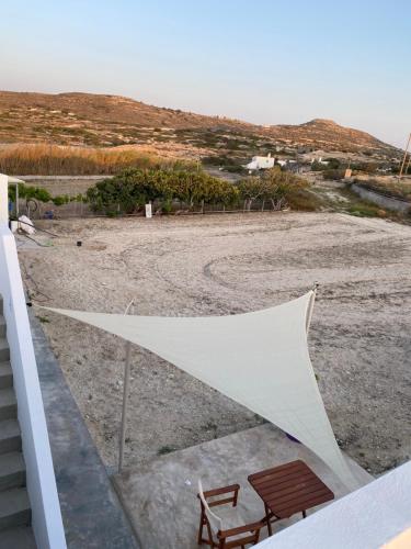 a tent sitting on a beach with a bench at Amato in Mandrakia