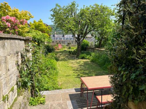 a picnic table in a garden with a tree at Stylish Central Apartment with Parking - Garden and Workspace in Bath