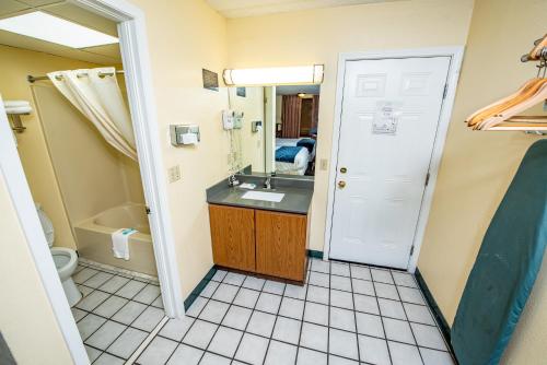 a bathroom with a sink and a toilet and a mirror at River Place Inn in Pigeon Forge