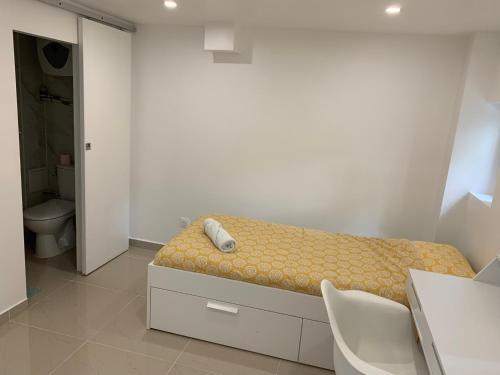a small bedroom with a bed and a bathroom at Chambre 14m2 in Massy