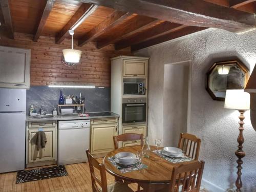 une cuisine avec une table en bois et une salle à manger dans l'établissement Mimi Pinson Bugey idéale déplacement pro/tourisme, à Souclin