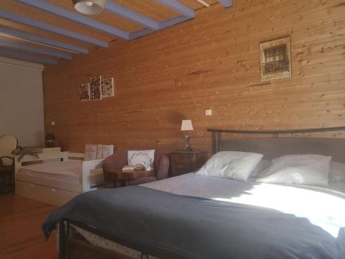une chambre avec un lit et un mur en bois dans l'établissement Mimi Pinson Bugey idéale déplacement pro/tourisme, à Souclin