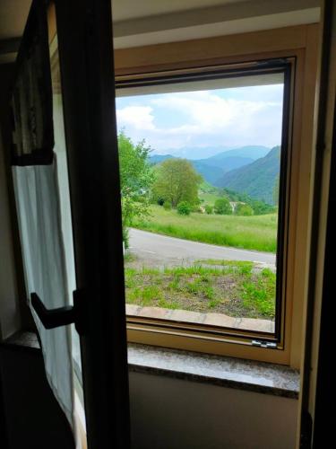 a window with a view of a mountain view at CHALET SIMONETTA - Locanda da Tullio in Capovalle