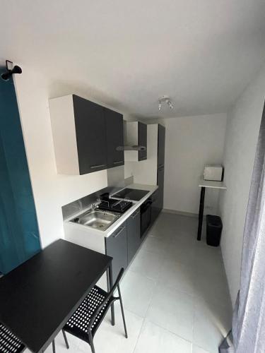 une petite cuisine avec un évier et une table dans l'établissement Studio neuf, à Marseille