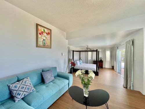 sala de estar con sofá azul y mesa en Olive Branch Villa *Luxury/ Fine Dining*, en Oracabessa