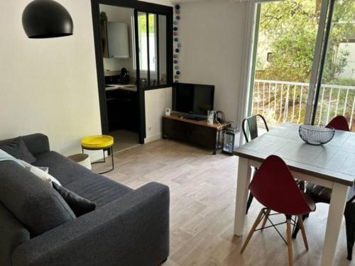 a living room with a couch and a table at Appartement avec Wifi La Baule Les Pins in La Baule