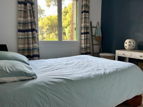 a bedroom with a white bed with a window at Appartement avec Wifi La Baule Les Pins in La Baule