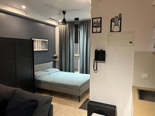 una piccola camera con letto e divano di London Studio @hiranandani thane a Thane