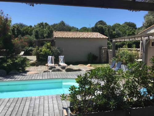 a swimming pool in a yard with two lawn chairs at songes d été2 in Bonifacio