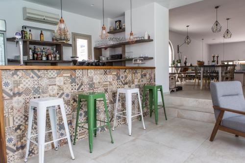a bar with green stools in a restaurant at Argo Boutique Hotel in Naxos Chora