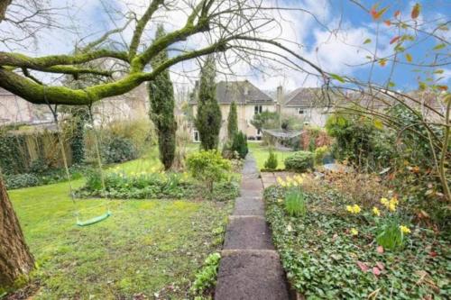 a garden with a tree and a pathway at Home in Midsomer Norton, near Bath & Bristol in Midsomer Norton