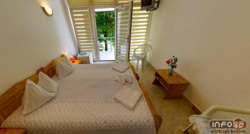 a bedroom with two twin beds and a window at Complex Credo in Costinesti