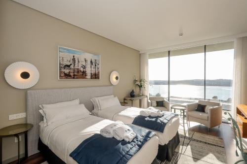 two beds in a room with a view of the water at Villa Paladina in Foz do Arelho