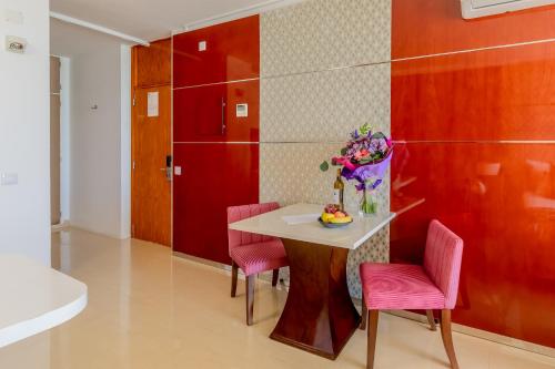 ein Esszimmer mit einem Tisch und rosa Stühlen in der Unterkunft Monicca Collection Suites and Residences in Albufeira