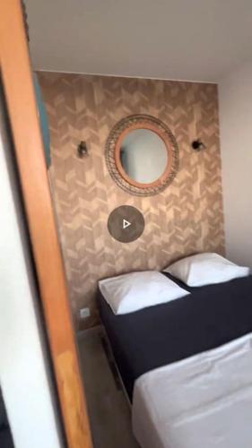 une petite chambre avec un miroir et deux lits dans l'établissement Appart Vue Mer Canet plage, à Canet