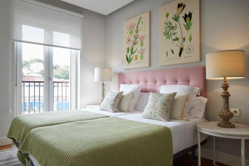 2 camas en un dormitorio con cabecero rosa en Mirakruz H by FeelFree Rentals, en San Sebastián