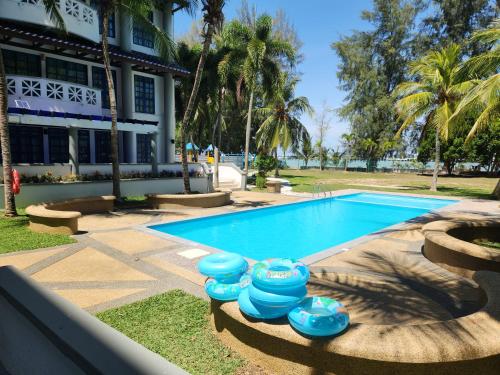basen z niebieskimi miskami obok budynku w obiekcie Long Sands Port Dickson w mieście Port Dickson