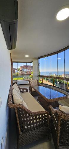a room with wicker furniture and a view of the ocean at RizeKonak Luxury Villa Private Garden Ac Sea View in Rize