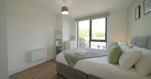 une chambre avec un lit et une grande fenêtre dans l'établissement Modern 2-Beds - City Centre - FREE Wi-Fi - New -, à Sheffield