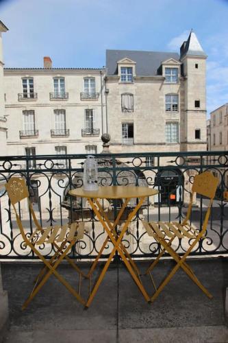- un balcon avec une table et des chaises dans l'établissement Très lumineux, au coeur de la vieille ville, 86 m², à La Rochelle