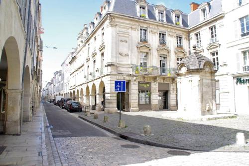 uma rua de calçada em frente a um grande edifício em Très lumineux, au coeur de la vieille ville, 86 m² em La Rochelle