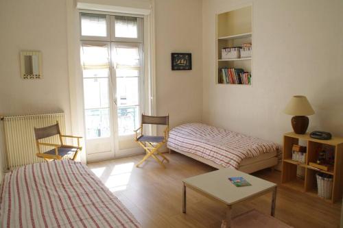 uma sala de estar com uma cama e uma mesa em Très lumineux, au coeur de la vieille ville, 86 m² em La Rochelle