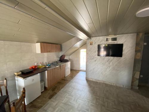 a kitchen with a sink and a tv on a wall at Vista Point Apartment in Bajina Bašta