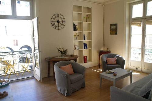 - un salon avec deux chaises et une horloge murale dans l'établissement Très lumineux, au coeur de la vieille ville, 86 m², à La Rochelle