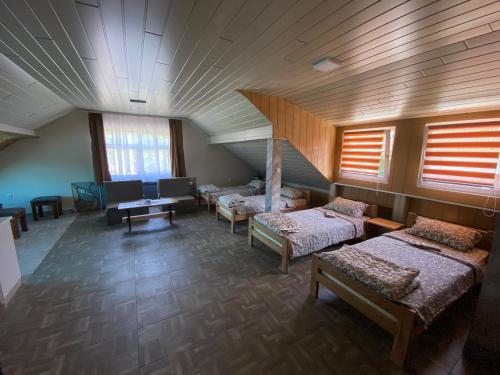 a room with four beds and a staircase with windows at Vista Point Apartment in Bajina Bašta