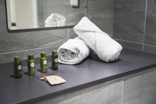 a bathroom counter with towels and toiletries on it at Modern 2-Beds - City Centre - FREE Wi-Fi - New - in Sheffield
