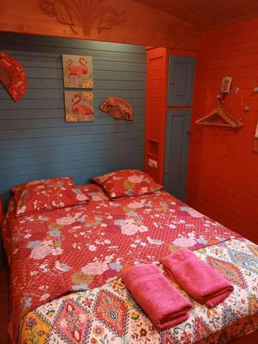 une chambre avec un lit avec des oreillers roses dessus dans l'établissement Roulotte des Alpilles, à Maussane-les-Alpilles