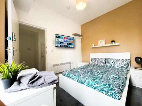 a bedroom with a bed and a tv on the wall at Charming Retreat in the heart of the City in Liverpool