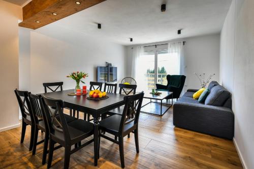 uma sala de jantar e sala de estar com uma mesa e um sofá em Kuća za odmor Bubamara em Ravna Gora