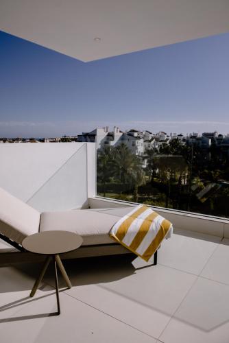 a bed and a table in a room with a window at THE FLAG HOTEL Marbella, Estepona Adult Recommended in Estepona