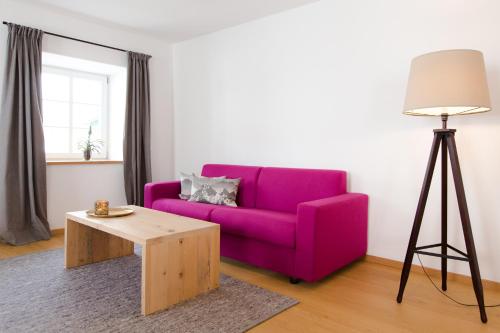 a living room with a purple couch and a table at Guade Stub´n in Garmisch-Partenkirchen