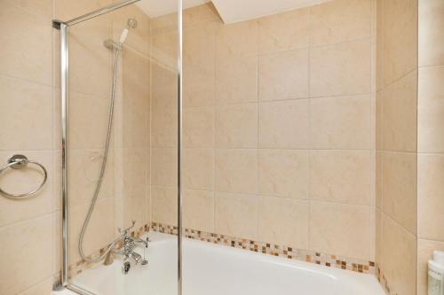 a bathroom with a shower and a bath tub at The Holland Park Crib - Classy 2BDR House in London