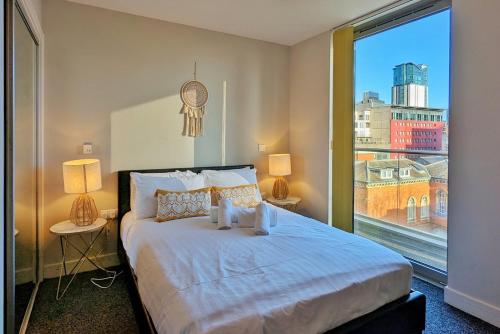 a bedroom with a bed and a large window at Viva 1 Bed Apartment Birmingham City Centre in Birmingham