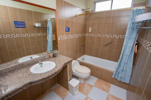 a bathroom with a sink and a toilet and a tub at Blue Marlin Hotel in Puerto Baquerizo Moreno