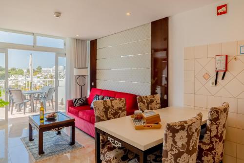 a living room with a red couch and a table at Monicca Collection Suites and Residences in Albufeira