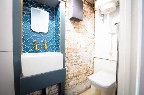 La salle de bains est pourvue d'un lavabo et de toilettes. dans l'établissement Modern flat with KING bed, garden & outdoor dining, à Londres