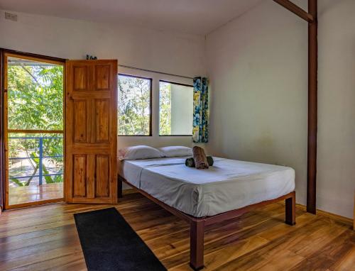 a bedroom with a bed and a large window at Uvita River Guesthouse in Uvita