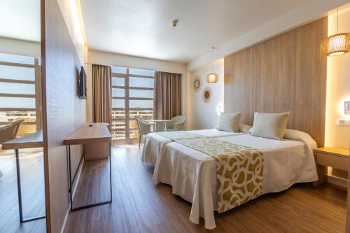 a hotel room with a large bed and a balcony at Ona Palmira Paradise in Paguera