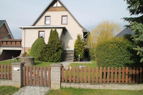 uma casa com uma cerca de madeira em frente em Alt Sammit em Alt Samitz