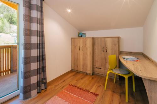 a room with a desk and a yellow chair at Balbeinhof Apt Gams in Luson