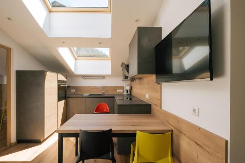 a kitchen with a wooden table and yellow chairs at Balbeinhof Apt Gams in Luson