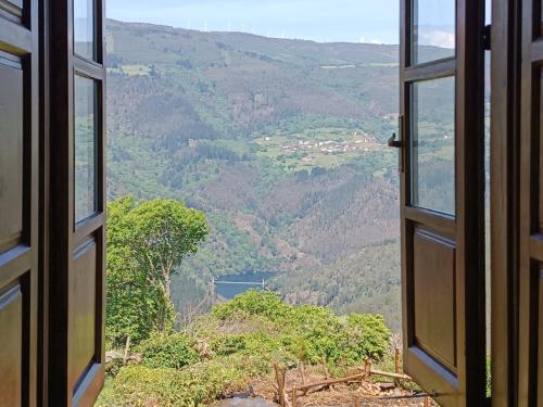 een open raam met uitzicht op een vallei bij Apartamentos Rurales San Esteban de los Buitres - Illano 