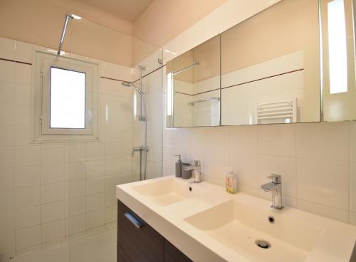 a white bathroom with a sink and a mirror at Pascalou - Hossegor situation privilégiée entre lac et océan pour cette villa in Soorts-Hossegor