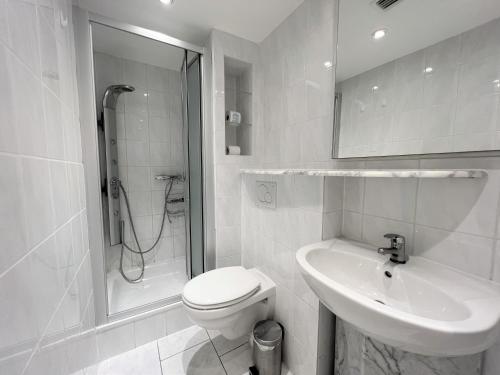 uma casa de banho com um WC, um lavatório e um chuveiro em Panoramic App B02-6 em Sierksdorf